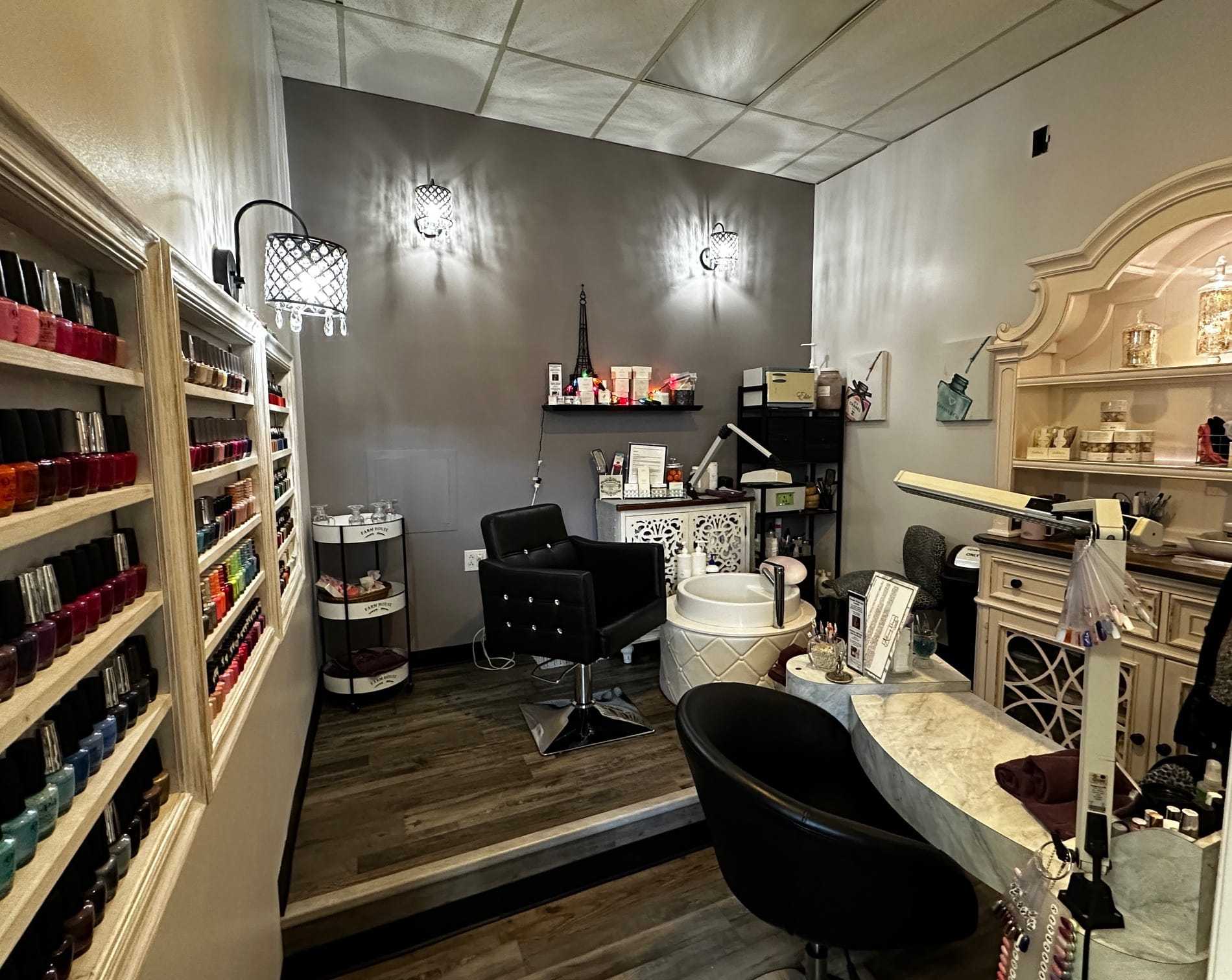A well-lit, modern nail salon with polish displays, manicure stations, and elegant decor.